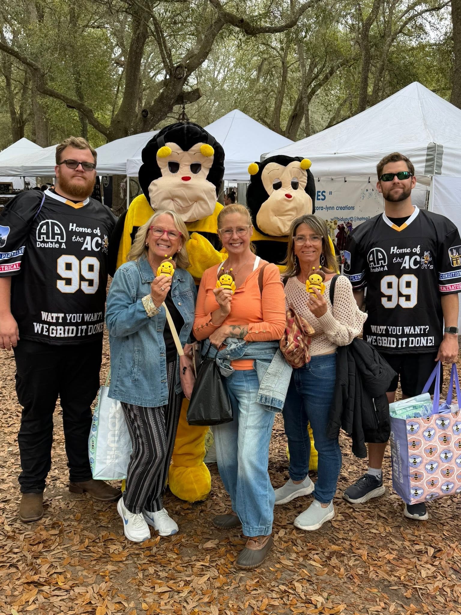 Group of community members holding bee toys with AC Bee mascots and Double A team