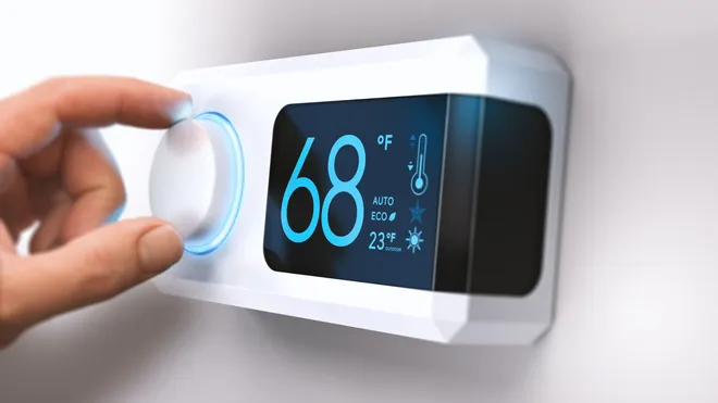 Modern digital thermostat displaying 68°F temperature.