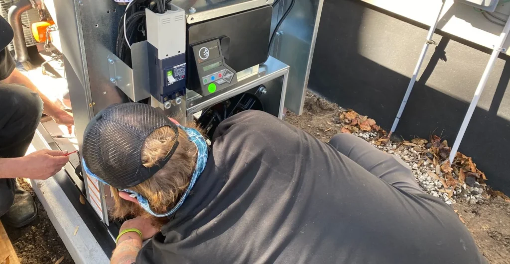 Person working on a furnace or HVAC system inside a building.