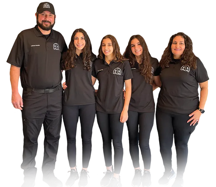 A group of five people wearing matching black outfits posing together.