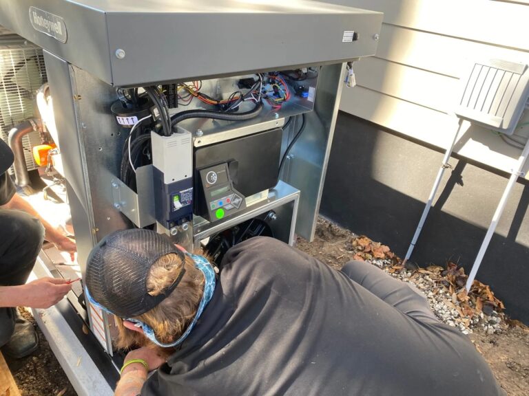 Technicians working on an outdoor generator unit.