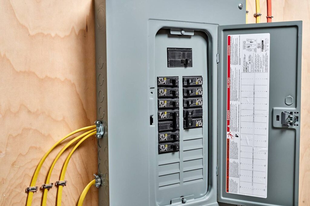 Electrician with wires switching off circuit breakers